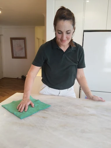 Annie cleaning a kitchen bench