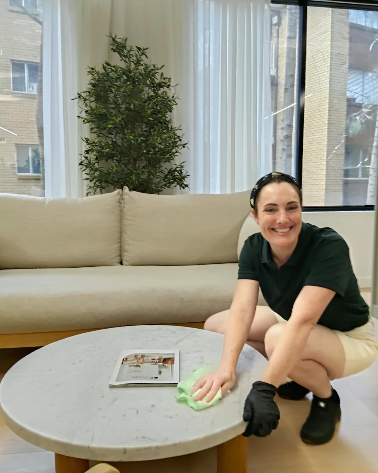A Gumnut cleaner wiping a marble coffee table in a client's living room