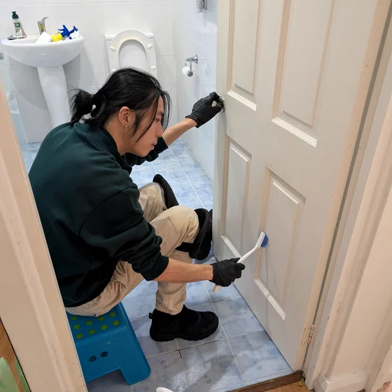 Jean cleaning a door frame